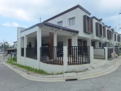 White two-storey house on a corner lot with a steel fence