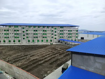 Five-storey accommodation building with blue roofing beside a second block