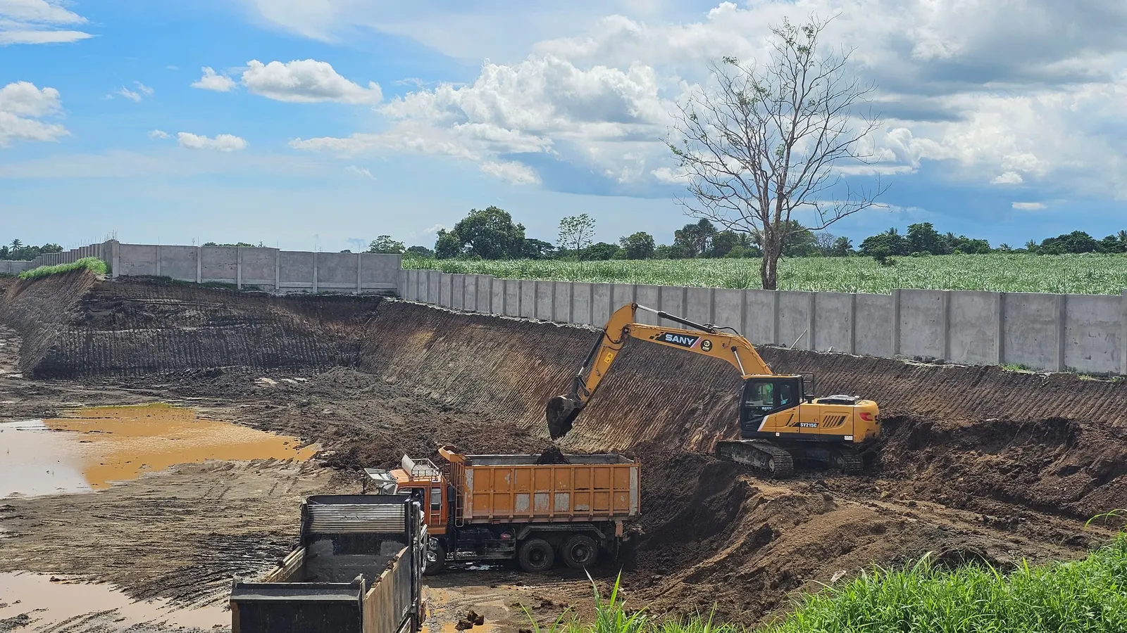 Excavator loading a dump truck during earthworks