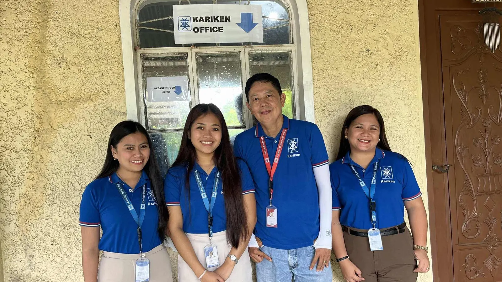 Kariken staff in company shirts at the Kariken office door