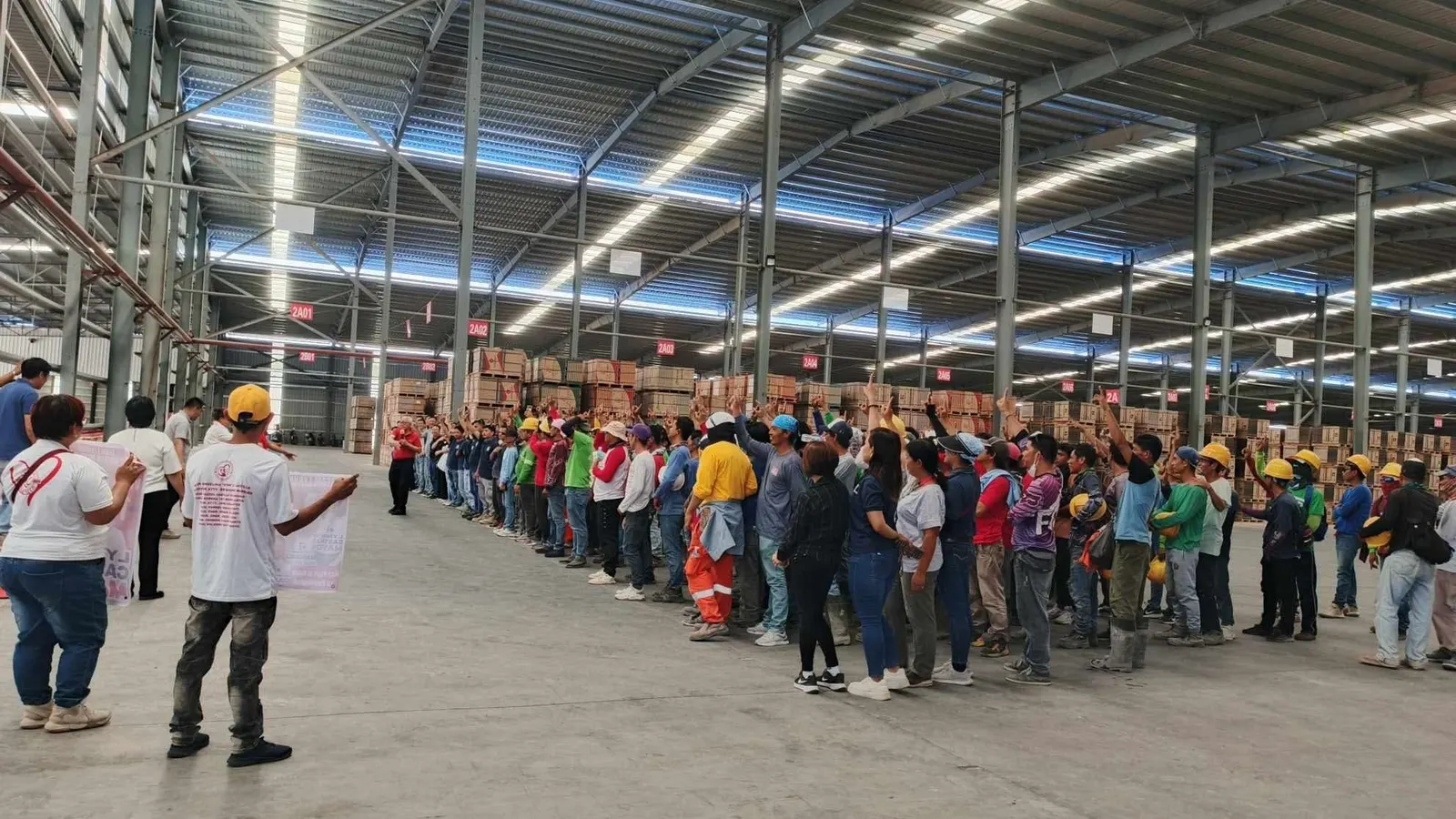 Kariken personnel assembled for a monthly workforce meeting inside a warehouse